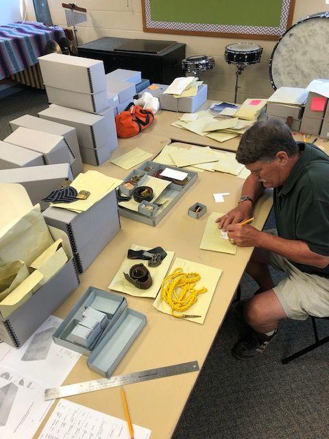 Butch Maisel ’72 carefully records research for each piece of McDonogh School military insignia so it can eventually be cataloged into a content management database system.